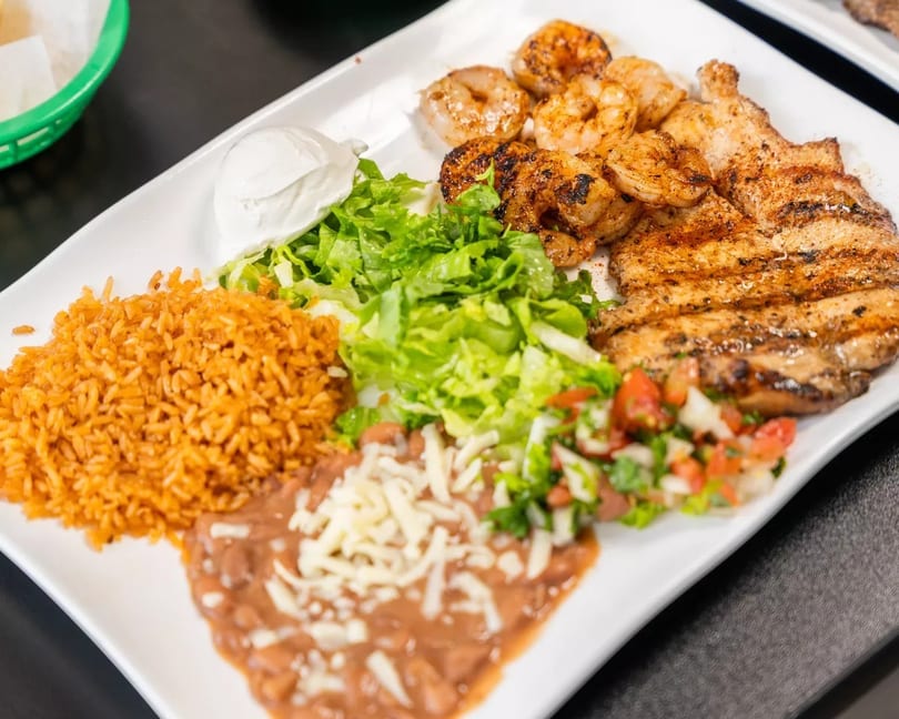 Grilled chicken and shrimp with rice, refried beans, lettuce, pico de gallo, and sour cream.